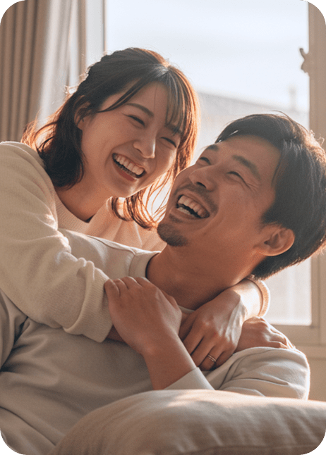 ソファで寄り添い笑い合うカップル